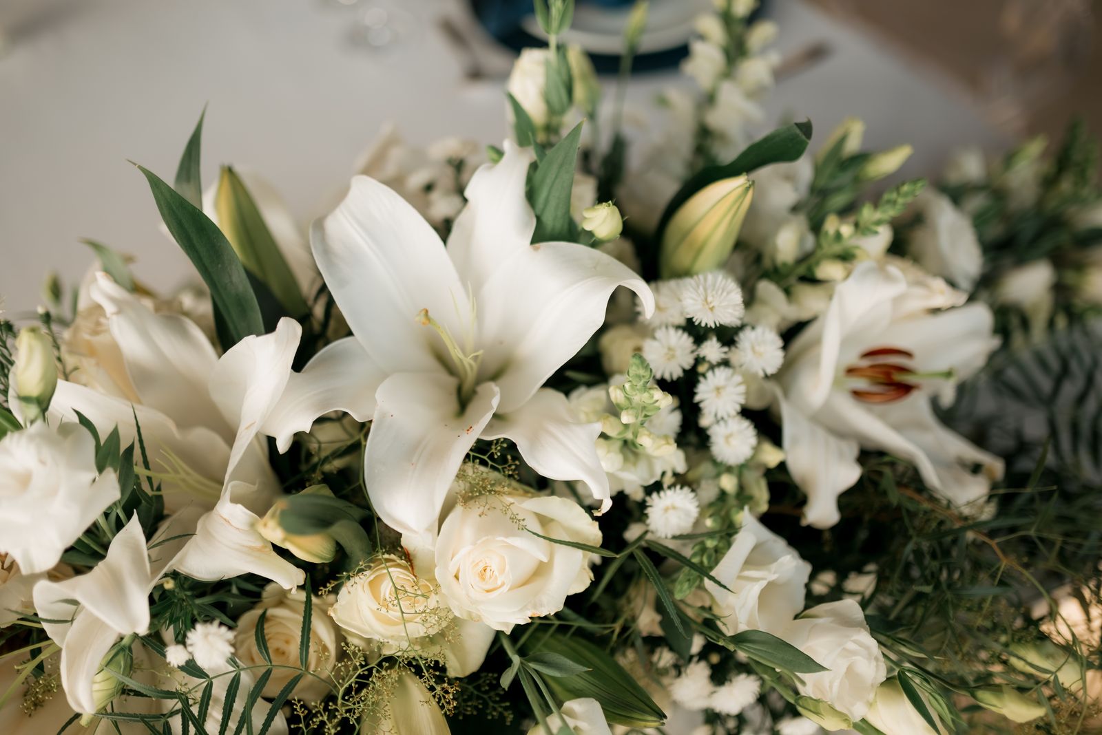 Composition de lys blancs et de roses crème pour une cérémonie